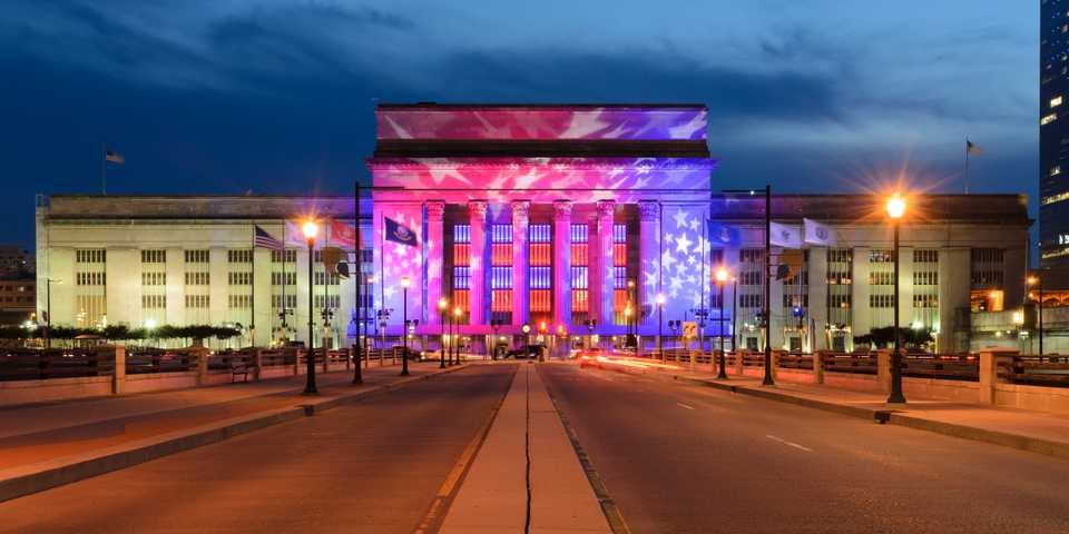 Alt Text / photo of 30th street station with an American Flag projected onto the facade